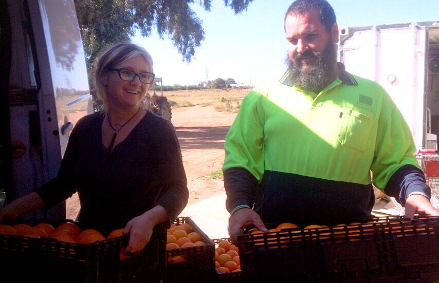 Phoebe and Francis with citrus harvest, on family farm. The Orange Lady.