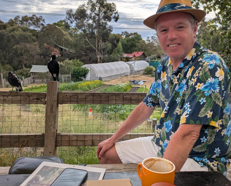 Visitor enjoying a coffee at CERES Grocery, overlooking Honey Lane Market Garden, East Brunswick.